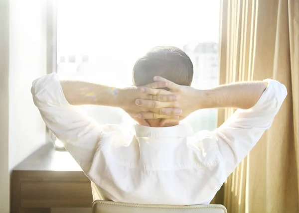 Rear view of man relaxing on chair at home — Stock Photo, Image