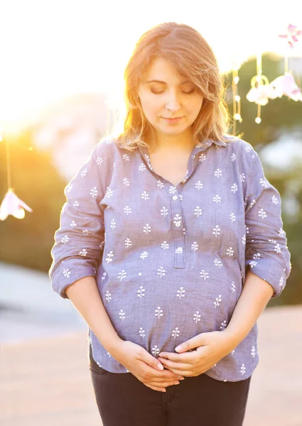 Pregnant woman against backdrop of city — Stock Photo, Image