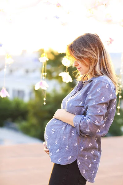 Gravid kvinna mot bakgrund av staden — Stockfoto