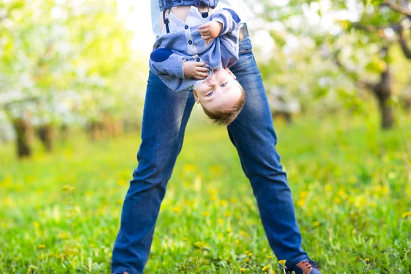 Baby jongetje met moeder in de bloeiende tuin — Stockfoto