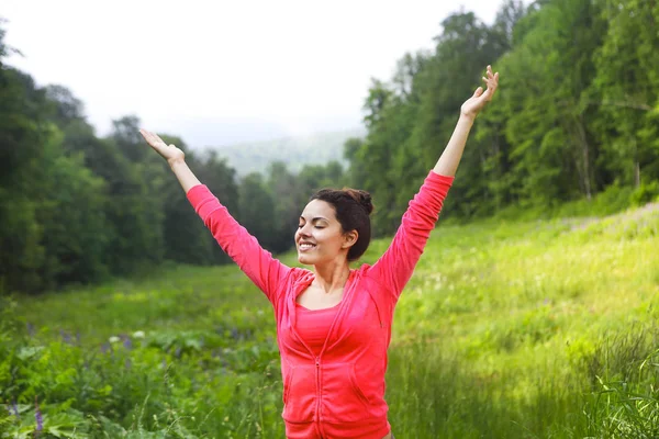 Happy young woman raised hands up at mountain forest Royalty Free Stock Photos