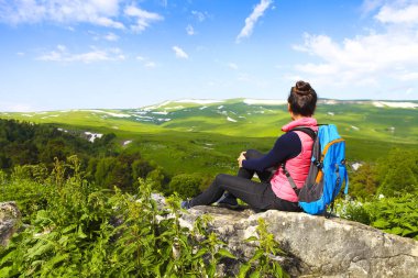 Uzun yürüyüşe çıkan kimse bir dağın tepesinde rahatlatıcı ve v zevk sırt çantası ile