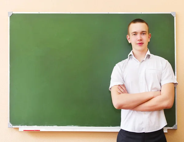 Student boy standing near the blackboard — Stock Photo, Image