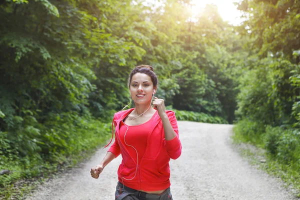 Jeune femme courant sur une route rurale le matin — Photo