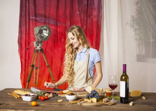 Felice donna bionda che cucina in cucina — Foto Stock