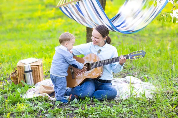 Little baby boy with mother in the blossoming garden — Stock Photo, Image