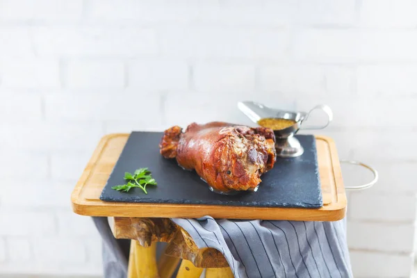 Rostad gris ben (rulka) serveras med vitlökssås på trä — Stockfoto