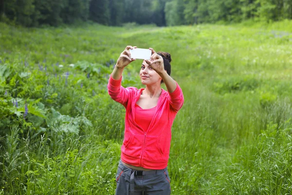 Vrouw maken foto bergbos — Stockfoto