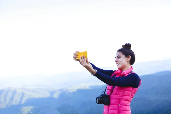 女性ハイカーが山ピーク時にスマート フォンで写真を撮影 — ストック写真