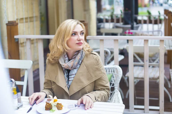 Close up happy adult blond woman in outdoors cafe looking into d — Stock Photo, Image