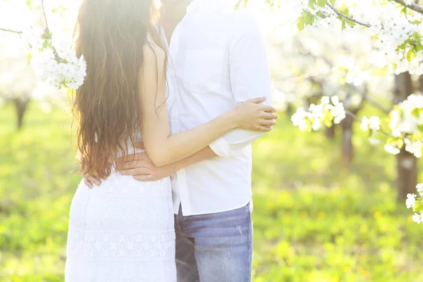 Pasangan yang jatuh cinta berciuman dan berpelukan di taman musim semi — Stok Foto