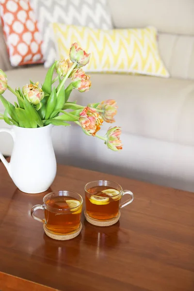 Belo buquê de tulipas laranja com duas xícaras de chá — Fotografia de Stock