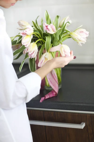 Mulher organizando buquê floral em uma cozinha — Fotografia de Stock