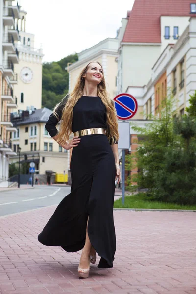 Vacker blond kvinna i lång klänning promenader utomhus — Stockfoto
