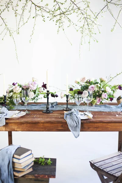 Sträuße mit rosa Blumen auf einem Tisch zum Abendessen mit Kerzen — Stockfoto