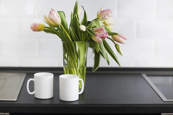 Bouquet di tulipani rosa in vaso di vetro in cucina — Foto Stock