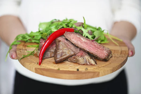 Filete de ternera a la parrilla medianamente rebanado Ribeye en manos de una mujer —  Fotos de Stock