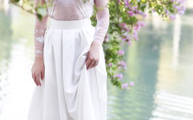 Gün batımında göl kenarında duran güzel gelin