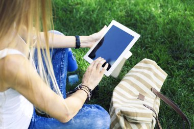 Kızın bir doğa arka plan üzerinde bir el içinde tablo pc