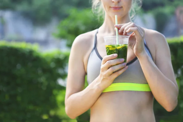 Fitnesssportlerin ruht sich aus und trinkt Bio-Drink — Stockfoto