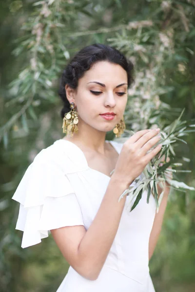 Portret jonge bruid met donkerbruine haren in witte trouwjurk een — Stockfoto