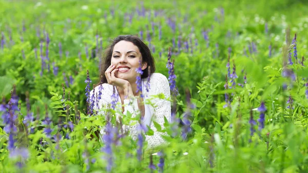 Mujer morena bonita feliz en el campo de flores — Foto de Stock