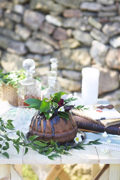 Bolo de chocolate decorado com flores e três decantadores de uísque — Fotografia de Stock