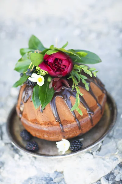 Schokoladenkuchen mit frischen Brombeeren und Blumen dekoriert — Stockfoto