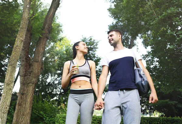 Jovem casal caminhando no parque após a atividade esportiva — Fotografia de Stock