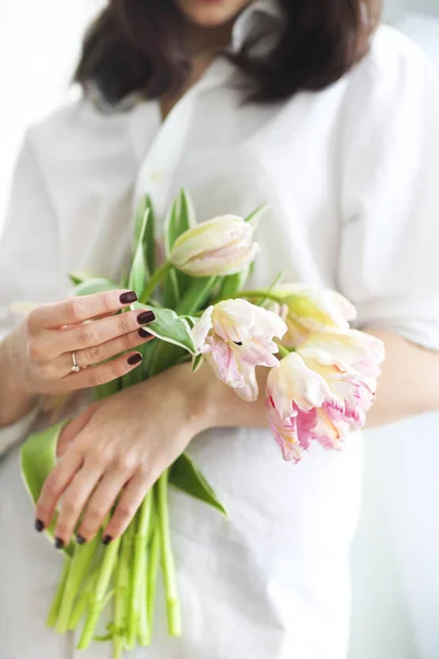 Belle jeune femme tenant un bouquet de délicat printemps rose tu — Photo
