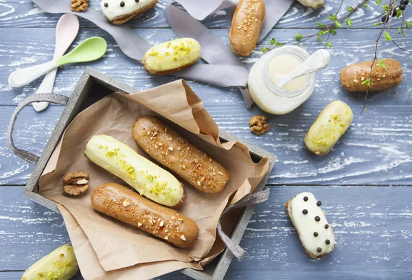 Eclairs com chocolate e chantilly no fundo escuro — Fotografia de Stock