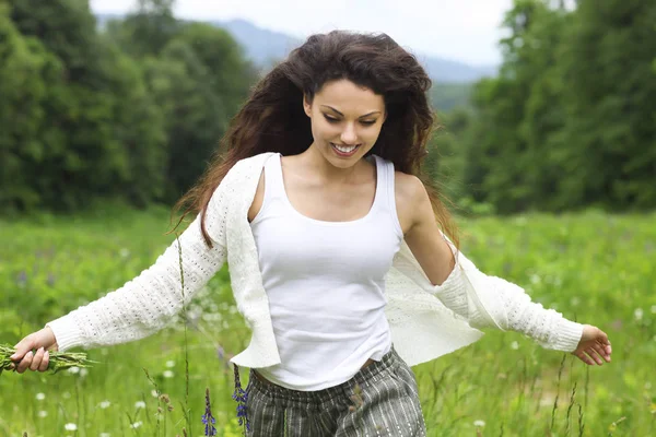 Happy pretty brunette woman in romomile field, cute female rela — стоковое фото
