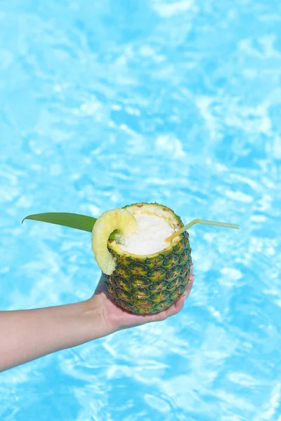 Hand med ananas exotiska coctail nära poolen — Stockfoto