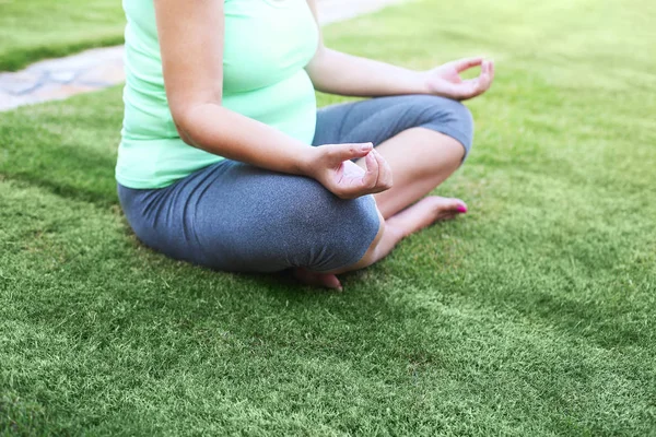 Beautiful pregnant woman meditaiting in summer park. — Stock Photo, Image