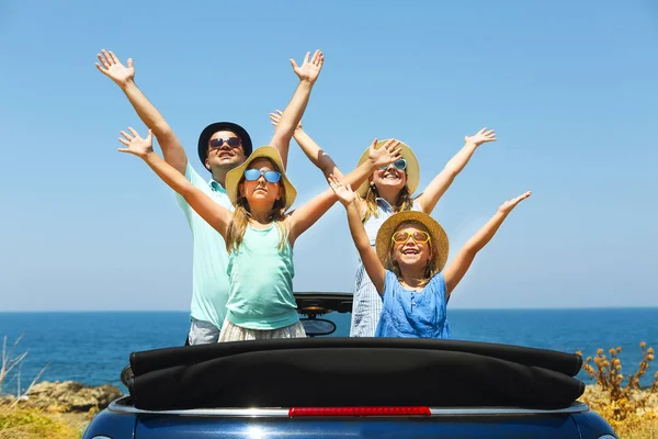 Portret van een lachende gezin met twee kinderen op het strand in de c — Stockfoto