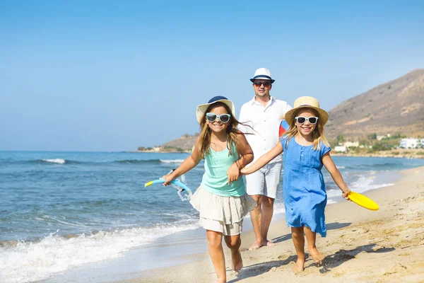 Feliz joven familia divirtiéndose corriendo en la playa al atardecer. Familia —  Fotos de Stock