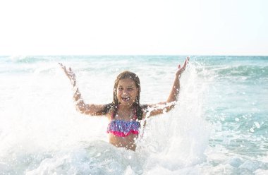 Açık havada oynayan mutlu çocuk. Çocuk denizde eğleniyor. Yaz 