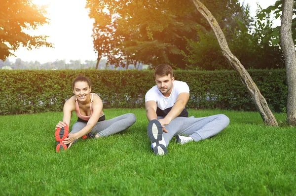 Glada sportiga unga par träning utomhus — Stockfoto