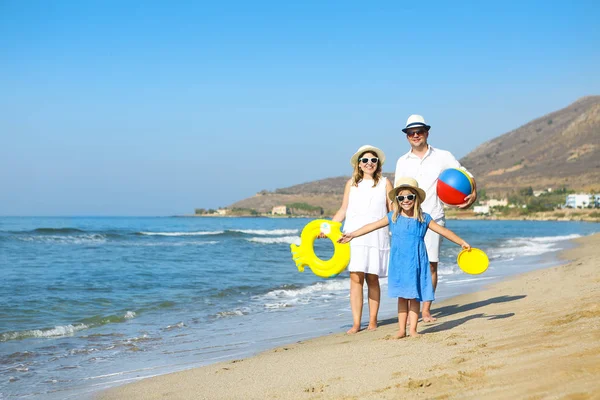 Szczęśliwe rodziny młodych zabawy działa na plaży o zachodzie słońca. Rodzina — Zdjęcie stockowe