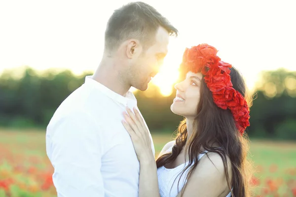 Молодая пара влюбленных целуется и обнимается на маковом поле — стоковое фото