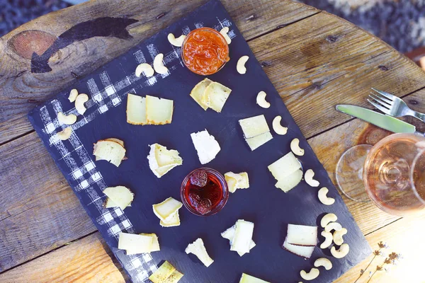 Uva, conjunto de diferentes tipos de queijos com um copo de vitória rosa — Fotografia de Stock