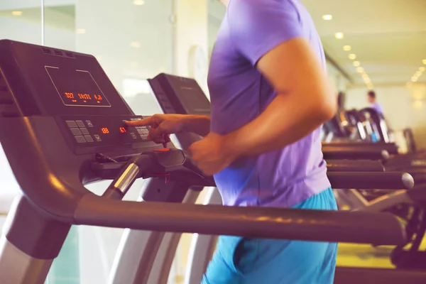 Gesunder junger Mann trainiert auf einem Laufband in einem Sportzentrum — Stockfoto