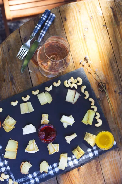 Grape, set of different kind of cheeses with a glass of pink win — Stock Photo, Image
