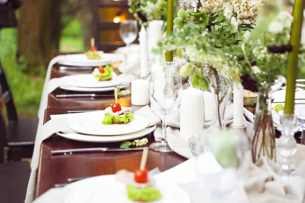 Decoration of wedding table with crystal vases, flowers in botan