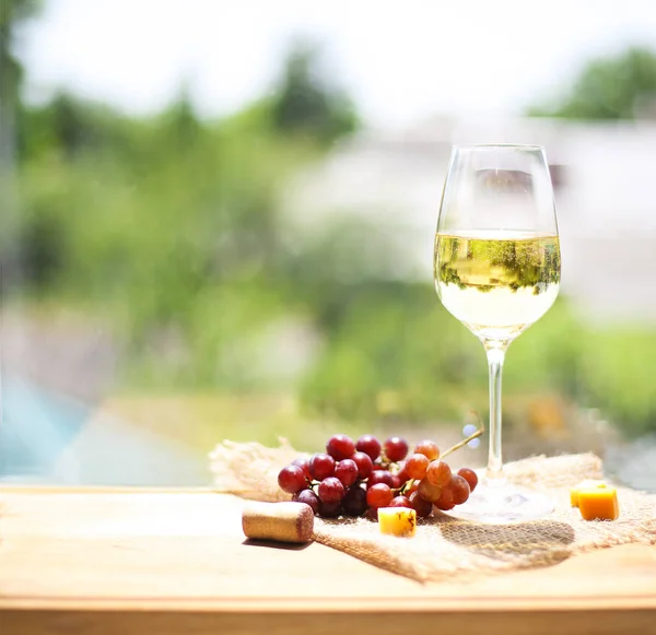 Uva, queso con una copa de vino blanco — Foto de Stock