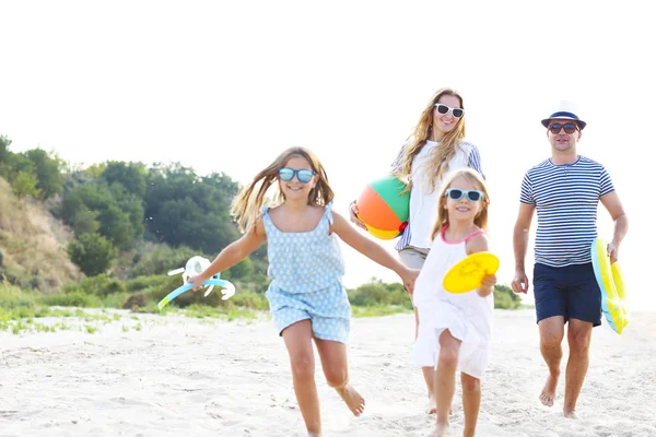 Familj med barn som springer på stranden — Stockfoto
