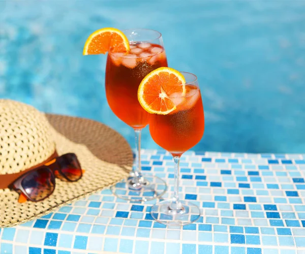 Glasögon av orange alkohol cocktail på turquiose vatten bakgrund — Stockfoto