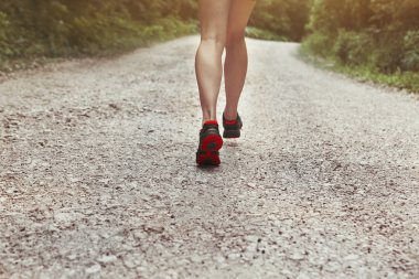 Genç fitness kadın atlet yolda koşuyor.