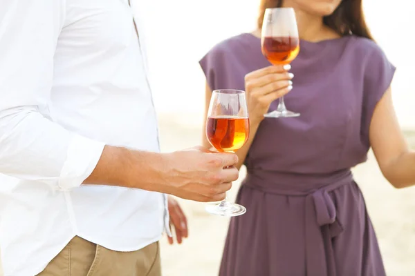 Man en vrouw met wijnglazen buitenshuis — Stockfoto