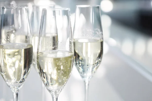 Bicchieri di champagne su sfondo bianco in luci brillanti — Foto Stock